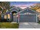 Beautiful gray single-Gathering home with garage, arched entryway, and manicured lawn, under a colorful sky at 816 Garden Glen Loop, Lake Mary, FL 32746