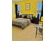 Bright bedroom with yellow walls featuring a patterned bed, creating a cheerful atmosphere at 8813 Dunes Ct # 7 201, Kissimmee, FL 34747