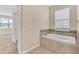 A bathtub is surrounded by beige tile and mosaic tile accents in a bathroom at 8946 Azalea Sands Ln # 8946, Davenport, FL 33896