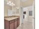 Bathroom featuring granite countertop, wood cabinetry, and tiled flooring is bright and airy at 8946 Azalea Sands Ln # 8946, Davenport, FL 33896