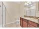 Bathroom featuring granite countertop, wood cabinetry, and tiled flooring next to a walk-in shower at 8946 Azalea Sands Ln # 8946, Davenport, FL 33896