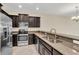 Modern kitchen with stainless steel appliances, dark cabinets and tile floors at 8946 Azalea Sands Ln # 8946, Davenport, FL 33896