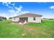 Rear exterior view of a home and lanai, with patio and a well-maintained lawn at 944 Lochland Loop, Bartow, FL 33830