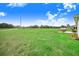 Large backyard with expansive grassy area and view of the home's lanai at 944 Lochland Loop, Bartow, FL 33830