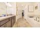 Bright bathroom offers a soaking tub, double sinks, and a doorway leading to a walk-in closet at 944 Lochland Loop, Bartow, FL 33830