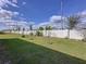 Spacious backyard enclosed by a white fence, featuring a well-maintained lawn and tasteful landscaping at 1042 Heirloom Dr, Haines City, FL 33844