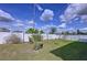 Expansive backyard with lush grass, young trees, and a pristine white fence, creating a serene outdoor oasis at 1042 Heirloom Dr, Haines City, FL 33844