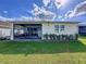 Green backyard with a screened-in patio, providing a relaxing outdoor space and manicured landscaping at 1042 Heirloom Dr, Haines City, FL 33844