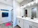 Well-lit bathroom with dual sinks, a glass-enclosed shower, and modern fixtures at 1042 Heirloom Dr, Haines City, FL 33844
