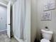 Cozy bathroom featuring beach-themed decor, a toilet, and a shower with a curtain at 1042 Heirloom Dr, Haines City, FL 33844