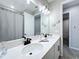 Bright bathroom boasts double sinks, modern fixtures, and decorative touches like fish wall art at 1042 Heirloom Dr, Haines City, FL 33844