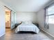 Sun-drenched bedroom boasts wood-look floors, neutral walls, and a modern sliding door to the bathroom at 1042 Heirloom Dr, Haines City, FL 33844