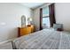 This bedroom features a wood dresser with a lamp, a decorative mirror and patterned bedding at 1042 Heirloom Dr, Haines City, FL 33844