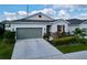 Charming one-story home featuring a gray garage door, red window shutter, and stone facade at 1042 Heirloom Dr, Haines City, FL 33844