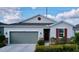 Charming single-story home with a gray garage door, stone accents, and inviting front entrance at 1042 Heirloom Dr, Haines City, FL 33844