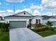 Charming one-story home featuring a gray garage door, red window shutter, and stone facade at 1042 Heirloom Dr, Haines City, FL 33844