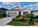 Charming one-story home with a gray garage door, red window shutter, and stone facade at 1042 Heirloom Dr, Haines City, FL 33844