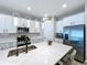 Modern kitchen features stainless steel appliances, an island, and pendant lighting at 1042 Heirloom Dr, Haines City, FL 33844