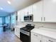 Bright kitchen with quartz counters, stainless appliances, and white cabinets at 1042 Heirloom Dr, Haines City, FL 33844