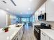 Open-concept kitchen with island seating, stainless steel appliances, and views to the dining area at 1042 Heirloom Dr, Haines City, FL 33844