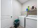 Practical laundry area equipped with appliances and shelf storage at 1042 Heirloom Dr, Haines City, FL 33844