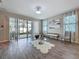 Bright living room featuring wood floors, modern decor, and sliding glass doors to a screened patio at 1042 Heirloom Dr, Haines City, FL 33844