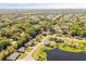 Aerial view of homes beside a scenic lake, showcasing lush trees and neighborhood streets for an attractive vista at 1062 Hidden Dr, Lakeland, FL 33809