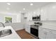 Bright kitchen with white cabinets, stainless steel appliances, and quartz countertops at 1062 Hidden Dr, Lakeland, FL 33809