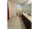 Bathroom featuring a double vanity, tiled flooring, and a shower, providing a practical and pleasant space at 112 Lake Tracy Ct, Haines City, FL 33844