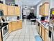 Open-concept kitchen with light wood cabinets, white countertops, and tile flooring at 1137 Cherry Valley Way, Orlando, FL 32828