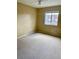 Bright, carpeted bedroom with large window for natural light and neutral walls at 1197 S Beach Cir, Kissimmee, FL 34746