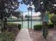 The tennis court is framed by lush trees and greenery, offering a serene recreational setting at 1197 S Beach Cir, Kissimmee, FL 34746