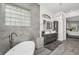 This bathroom boasts a modern tub, double vanity with stylish light fixture, and large glass-block window at 12177 Gray Birch Cir, Orlando, FL 32832