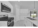 This modern kitchen features white cabinets, quartz countertops, and stainless steel appliances at 1252 Ash Tree Cv, Casselberry, FL 32707