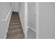 Carpeted stairway leads to a small tiled half bath with grey paint at 1252 Ash Tree Cv, Casselberry, FL 32707
