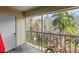 Screened balcony with tile flooring, metal railing, and views of the surrounding trees at 13829 Timberland Dr # 204, Orlando, FL 32824