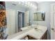 A full bathroom features a large mirror with vanity lighting, closet doors, and neutral color palette at 13829 Timberland Dr # 204, Orlando, FL 32824