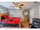 Comfortable bedroom with ceiling fan, carpet flooring, and a large round mirror at 13829 Timberland Dr # 204, Orlando, FL 32824