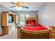 Bedroom featuring a ceiling fan, large window, and comfortable furnishings with a wooden bed frame at 13829 Timberland Dr # 204, Orlando, FL 32824
