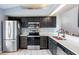 Modern kitchen with stainless steel appliances, black cabinets, and quartz countertops at 13829 Timberland Dr # 204, Orlando, FL 32824