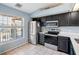 Modern kitchen features stainless steel appliances, sleek black cabinets, and a bright window at 13829 Timberland Dr # 204, Orlando, FL 32824