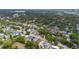 An aerial view showing houses nestled among lush trees, with a lake and the city skyline in the background at 1545 Indiana Ave # B, Winter Park, FL 32789