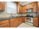A modern kitchen featuring wood cabinets, stainless steel appliances, and dark countertops at 1545 Indiana Ave # B, Winter Park, FL 32789