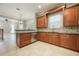 Well-designed kitchen with wood cabinets, stainless appliances, tiled floor, and an open view to the living room at 1545 Indiana Ave # B, Winter Park, FL 32789