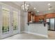 A well-lit kitchenette area with wood cabinets, stainless steel appliances and tiled floors leading to a small patio at 1545 Indiana Ave # B, Winter Park, FL 32789