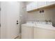 Bright laundry room with washer, dryer, white cabinets, and neutral wall color at 1545 Indiana Ave # B, Winter Park, FL 32789