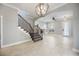 View of the staircase and living room with a fireplace and tiled floor in neutral colors with an elegant light fixture at 1545 Indiana Ave # B, Winter Park, FL 32789