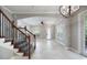 A bright living area with tiled floor, ceiling fan, chandelier, large windows, and view of the staircase at 1545 Indiana Ave # B, Winter Park, FL 32789