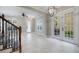 Spacious living room with tiled floors, a ceiling fan, a chandelier, and a glass door leading to an outdoor patio at 1545 Indiana Ave # B, Winter Park, FL 32789