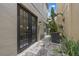Narrow stone paver patio with plants, AC unit, and outdoor access between two houses at 1545 Indiana Ave # B, Winter Park, FL 32789
